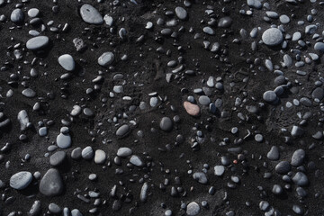 Texture of stones and black sand. Volcanic land, beach, natural pattern.