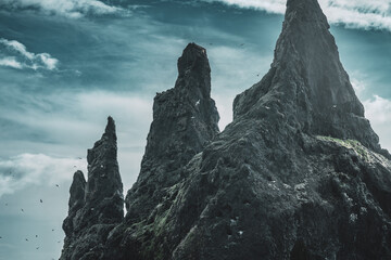 Reynisdrangar, black beach in Iceland. Famous basalt sea stacks under the mountain Reynisfjall,...