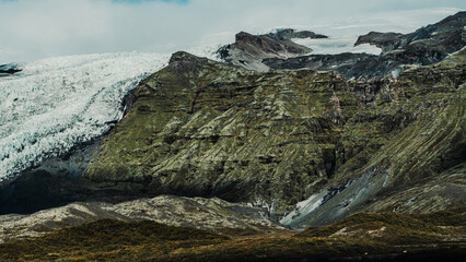 Icelandic panoramas, wide plains with mountains in the distance. Colours, volcanic lands, northern valleys. Dirt roads, farms, dark clouds and rivers.