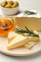 Tasty Camembert cheese with rosemary and honey on white table, closeup