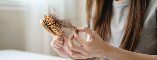 Close-up young woman brushing her hair and have many hair loss on the comb