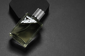 Stylish presentation of luxury men`s perfume in bottle on black background, space for text
