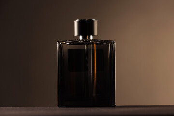 Luxury men`s perfume in bottle on table against color background
