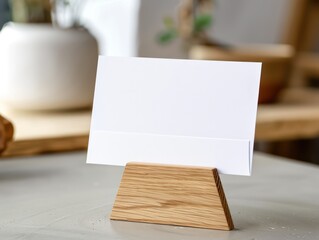 horizontal postal card in wooden stand, on top of a table