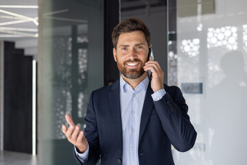 Confident businessman talking on phone in modern office
