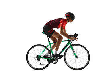 Young man, cycling athlete in sportswear and helmet riding bicycle, training against transparent background. Side view. Concept of sport, action, competition, power and endurance, health, marathon.