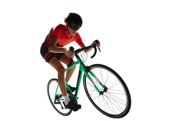 Muscular young man, athlete, cyclist in uniform and helmet, riding bicycle against transparent...