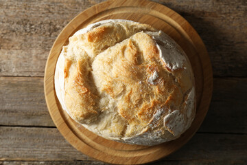 Freshly baked sourdough bread on wooden table, top view