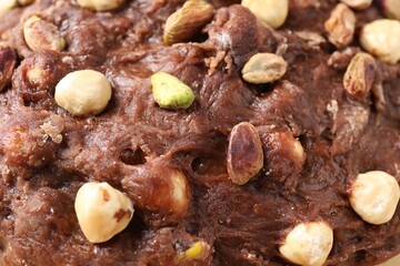 Raw chocolate dough with nuts as background, closeup