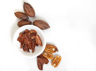 Whole and shelled pecan nuts isolated on white