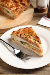 Piece of tasty homemade pie with filling served on wooden table