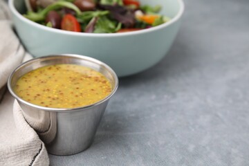 Tasty vinegar based sauce (Vinaigrette) in bowl on grey table, closeup. Space for text
