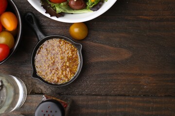 Tasty vinegar based sauce (Vinaigrette), tomatoes and spices on wooden table, flat lay. Space for text