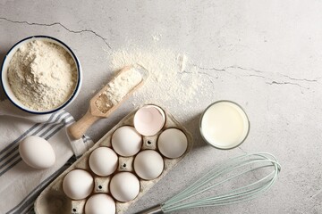 Making dough. Flour, eggs, milk and tools on light textured table, flat lay