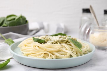 Tasty pasta with spinach, cheese and sauce on white marble table, closeup