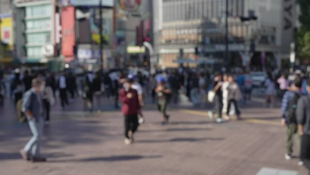 Blurred scene of crowd of people passing through the city.
