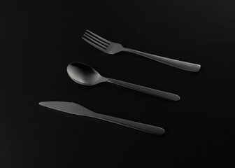 silvel steel fork, spoon, knife on a black backgrond