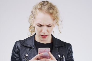 Woman, surprise and phone on studio background with stress for reading article, wtf news and social...