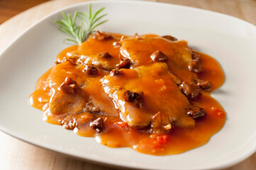 Veal fillets with tomato sauce and style mushrooms fricasse