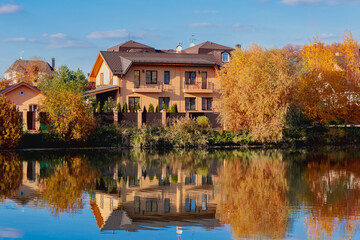 Lakeside homes. Rural area. Golden autumn. The conception of living by the lake.