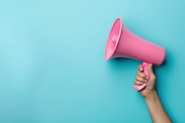 Pink megaphone held in hand on blue background, top view with copy space for text and messages communication concept