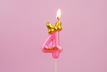 Burning pink birthday candle with golden bow and word happy on pink background, number 4.
