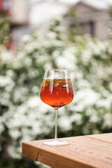 Elegant Cocktail in a Wine Glass on a Wooden Table - Refreshing Summer Drink with Mint Garnish, Captured in an Outdoor Garden Setting