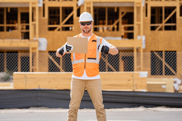 Man Contractor holds piece of empty cardboard sign in his hands. a male construction worker in a...