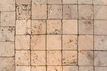The detail of worn stone paving blocks, showcasing their texture and the subtle color variations...