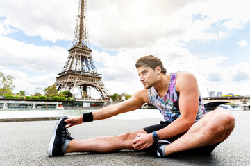 Man training and doing fitness exercises along the Seine river in Paris