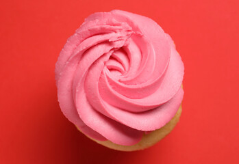 Delicious cupcake with bright cream on red background, top view