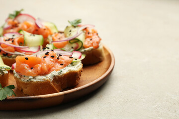 Tasty canapes with salmon served on light grey table, closeup. Space for text