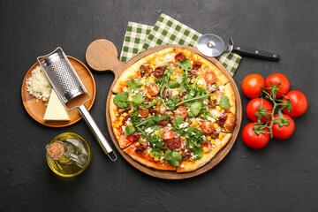 Delicious vegetarian pizza, ingredients, cutter and grater on black table, flat lay