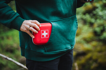 Person carrying first aid kit in sportswear pocket, ready for emergencies