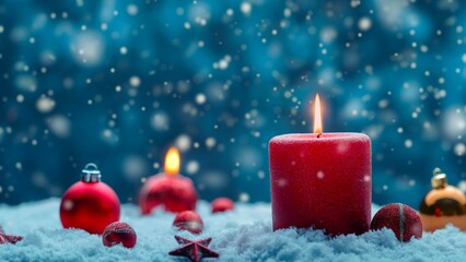 A red Christmas candle for Advent concept on a snowing night.