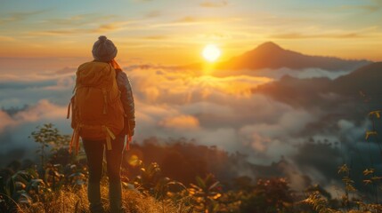 A young female backpacker happily looks at the mist and the morning sunrise while a young female backpacker soaks in the beauty of the mountain nature landscape during a blissful vacation trip.