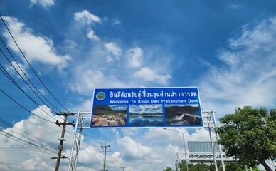 A Thai road sign translated into English reads: Welcome to khun dan prakanchon dam, a tourist...
