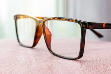 stylish glasses on table in office, eyeglasses contemporary on blurred background. business fashion