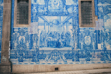 A blue and white wall in Porto, Portugal, featuring a clock. The wall is part of the Igreja do Carmo, a historic church in the city.