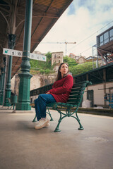 Woman sitting on a bench at porto train station