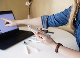 Toothpaste ingredients. Girl at laptop checks composition of toothpaste and is surprised by...