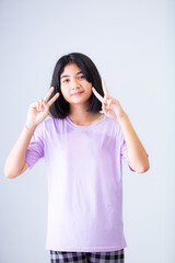 Smiling young Asian woman in casual outfit pointing away,Young Asian woman with short hair isolated on white background