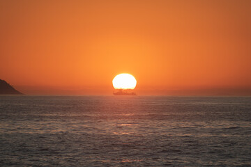 Sunset in the sea with navy ship