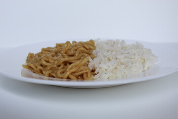 One plate of fried instant noodles and white rice, on white plate, isolated on white background