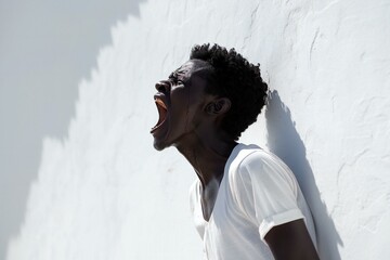Portrait of a young african american man standing against white wall