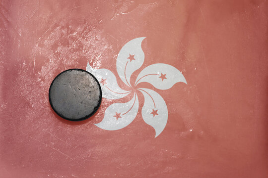 old hockey puck is on the ice with national flag of hong kong .