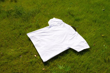 A white T-shirt is lying on the grass