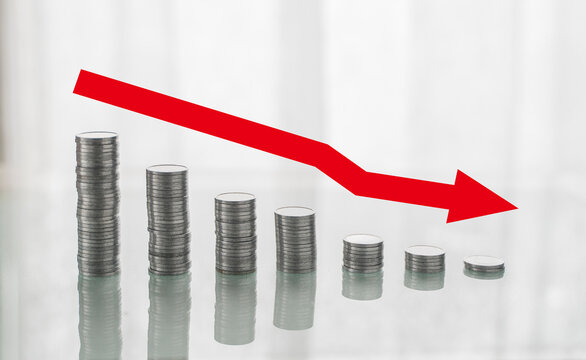 Background screen to demonstrate the decrease. Coins superimposed on the table representing decline. Red colored arrow represented decline
