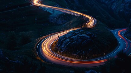 Car headlights and tail lights on a winding mountain road, nighttime driving