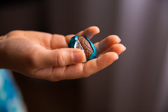 half unwrapped Easter egg in a childs hand